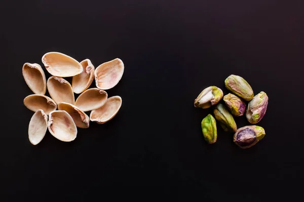 Vista superior de nutshells perto de pistácios isolados em preto — Fotografia de Stock