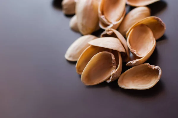 Close up view of shells form pistachio nuts on black — стоковое фото