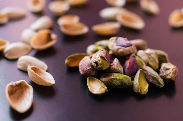 Primer plano de cáscaras de nuez y pistachos verdes salados en negro - foto de stock