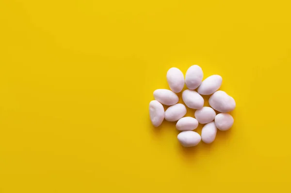 Vue de dessus des pignons de pin pelés sur fond jaune — Photo de stock