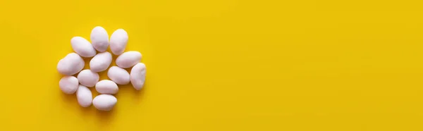 Top view of peeled pine nuts on yellow background, banner — Stock Photo