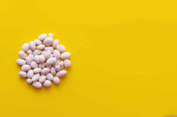 Top view of pile with peeled pine nuts on yellow background — Stock Photo