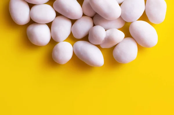 Close up view of peeled pine nuts on yellow background — Fotografia de Stock