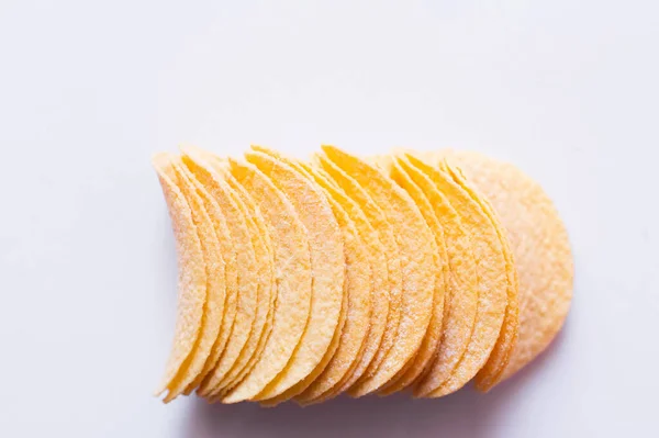 Top view of salty and crunchy potato chips on white — Stock Photo