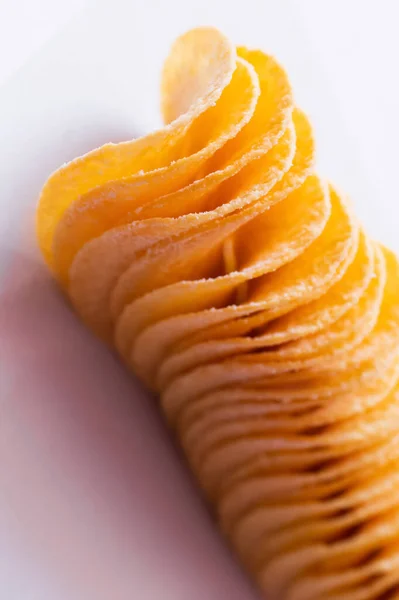 Close up view of salty and tasty potato chips on white — Stock Photo