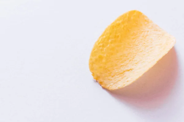 Blick von oben auf einzelne Kartoffelchips mit Salz auf Weiß — Stockfoto