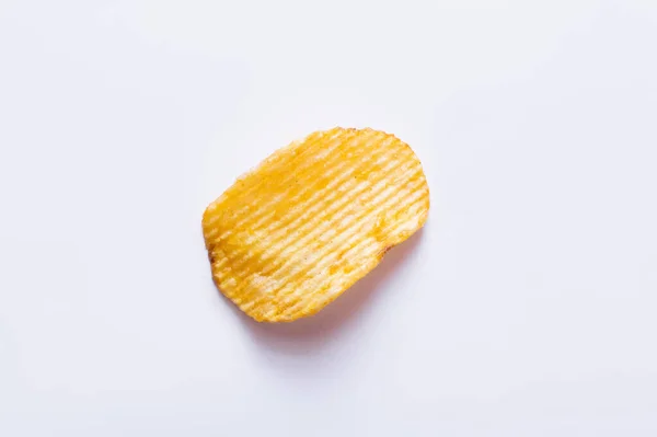 Top view of single wavy and salty potato chip on white - foto de stock