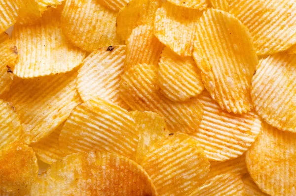 Bunch of wavy and salty potato chips, top view — Stockfoto