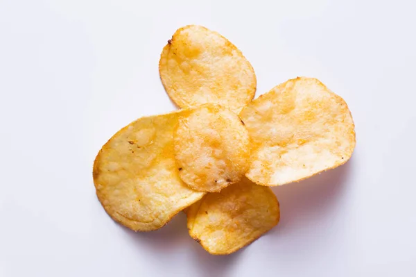 Top view of delicious, fried and salty potato chips on white - foto de stock