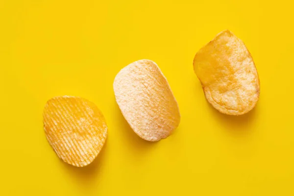 Top view of different salty potato chips on yellow — Foto stock