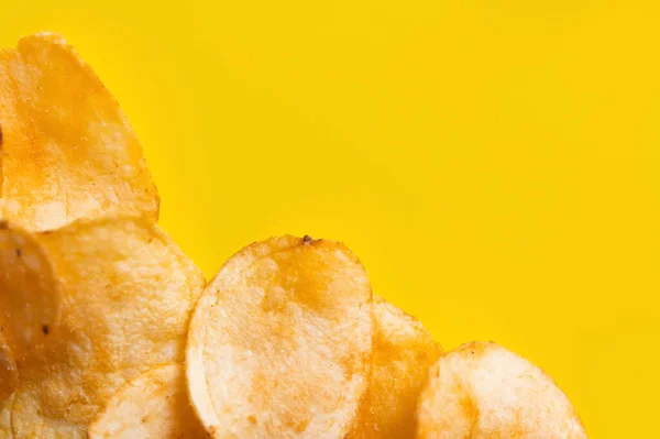 Top view of delicious, crunchy and salty potato chips on yellow — Fotografia de Stock
