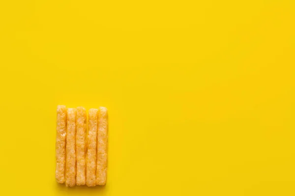 Top view of delicious and crispy french fries on yellow - foto de stock