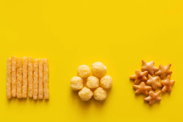 Top view of tasty french fries, cheese pops and bakes star shape cookies on yellow — Stockfoto