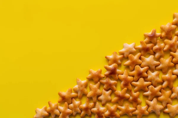 Flay lay view of tasty cookies in shape of stars on yellow — Foto stock