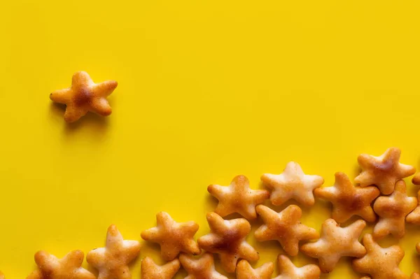 Top view of tasty cookies in shape of stars on yellow — Stock Photo