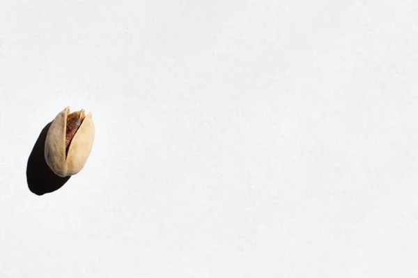 Top view of single cracked pistachio nut on white background — Stock Photo