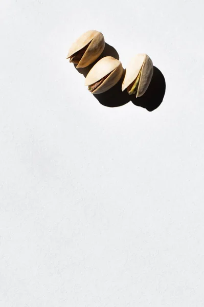 Top view of cracked and organic pistachio nuts on white — Foto stock