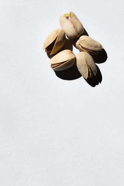 Top view of cracked and healthy pistachio nuts on white — стоковое фото