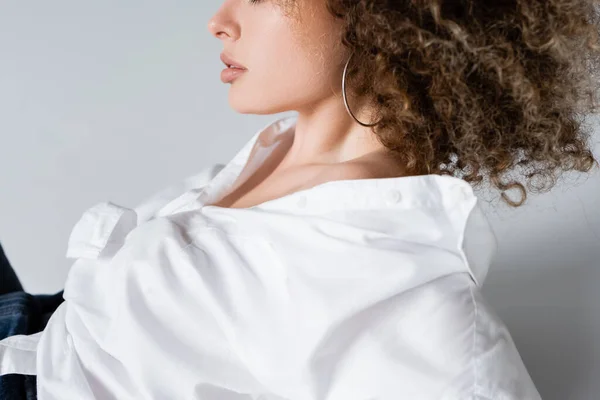 Cropped view of curly woman in blouse on white background — Stock Photo