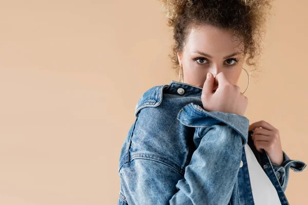 Junge Frau in Jeansjacke posiert isoliert auf beige — Stockfoto