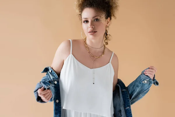 Portrait of woman in white top and denim jacket posing isolated on beige — Stock Photo