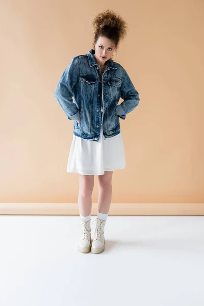 Full length of fashionable woman standing on beige background — Stock Photo