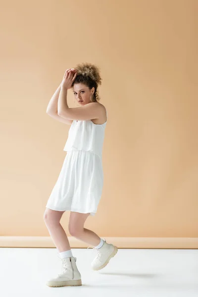 Stilvolles Model in weißer Kleidung posiert auf beigem Hintergrund — Stockfoto