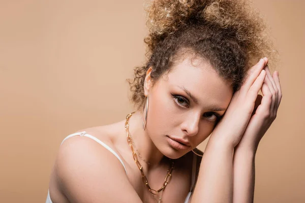 Portrait de jolie jeune femme en accessoires posant isolée sur beige — Photo de stock