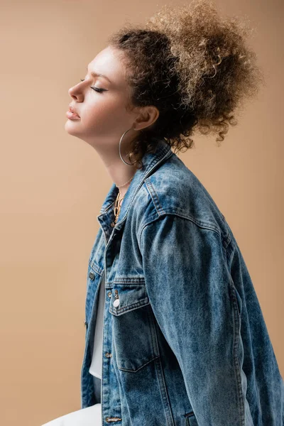 Молодая модель в джинсовой куртке и аксессуары, изолированные на бежевом — стоковое фото