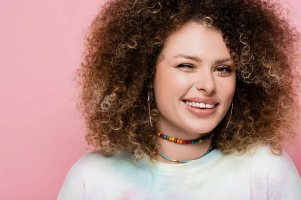 Portrait of smiling woman winking isolated on pink — Stock Photo