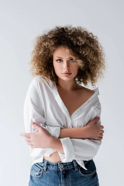 Retrato de jovem mulher encaracolada em blusa olhando para a câmera isolada no branco — Fotografia de Stock