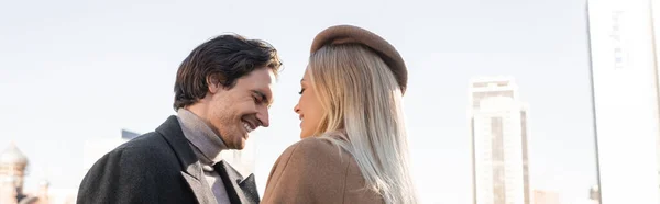 Jovem sorrindo perto da namorada na boina ao ar livre, banner — Fotografia de Stock