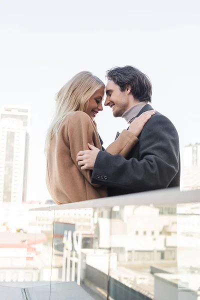 Side view of happy couple with closed eyes standing face to face outdoors — Stock Photo