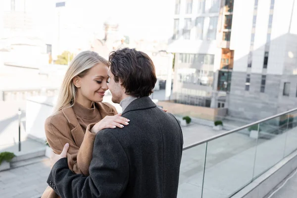 Romantic couple in autumn clothes standing face to face on city street — Stock Photo