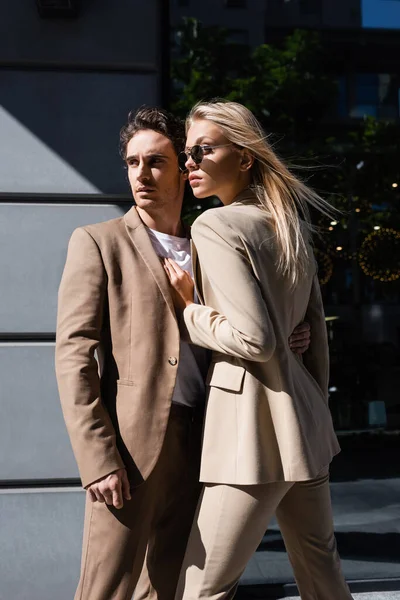 Mann umarmt stylische blonde Frau mit Sonnenbrille auf Stadtstraße — Stockfoto