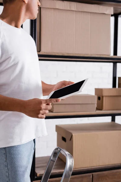 Cropped view of african american seller holding digital tablet near cardboard boxes in online web store — Stock Photo