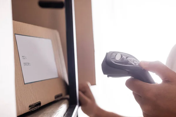 Cropped view of african american proprietor scanning box with shipping label in online web store — Stock Photo