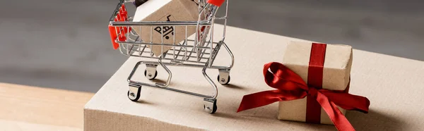 Toy cart near present on carton box, banner — Stock Photo