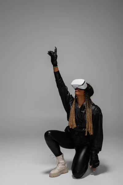 Africano americano mulher em luvas e vr headset jogos em fundo cinza — Fotografia de Stock