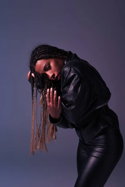 Trendy african american woman in leather jacket posing isolated on purple — Stock Photo