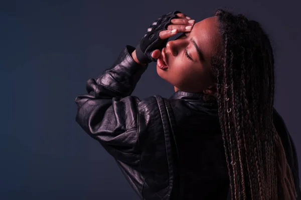 Modische Afroamerikanerin in Lederjacke posiert isoliert auf dunkelgrau — Stockfoto