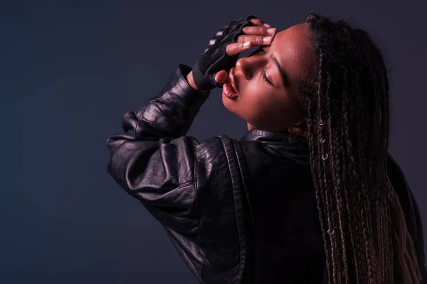 Fashionable african american woman in leather jacket posing isolated on dark grey — Stock Photo