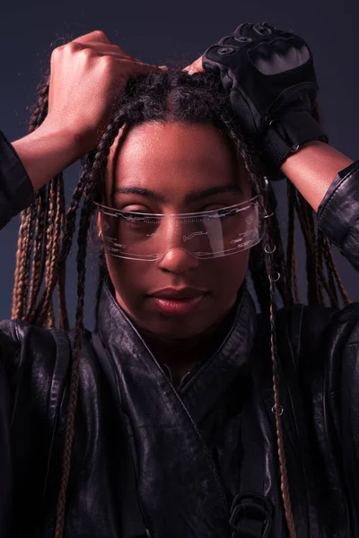Retrato de mujer afroamericana con estilo usando gafas inteligentes aisladas en gris oscuro - foto de stock