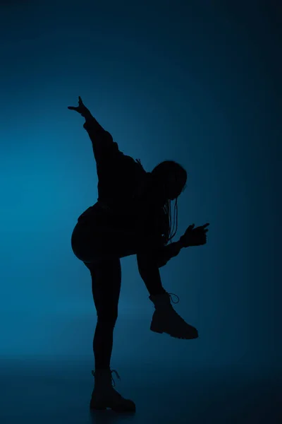 Силуэт африканской женщины-американки движется на темно-синем фоне — стоковое фото