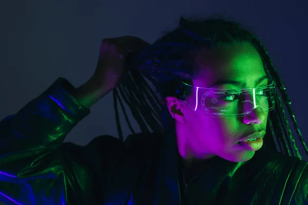 African american woman in smart glasses posing isolated on dark blue — Stock Photo