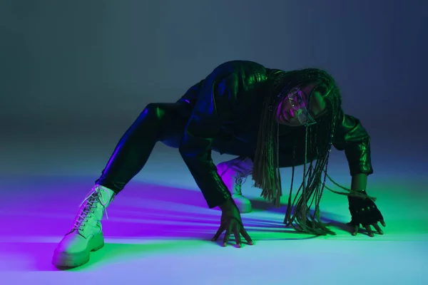 African american woman in smart glasses and leather jacket posing on blue background — Stock Photo