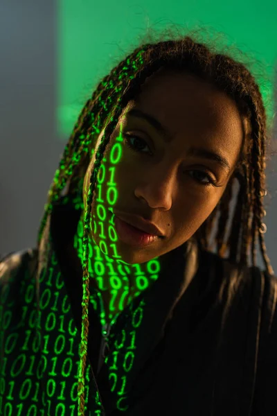 Portrait of african american woman with binary code on face on grey background — Stock Photo