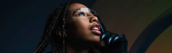 Femme afro-américaine en gant utilisant des lunettes intelligentes sur fond gris avec abstraction, bannière — Photo de stock