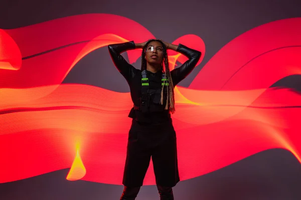 African american woman in smart glasses posing on red and grey abstracted background — Stock Photo