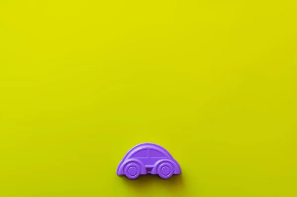 Vista superior do automóvel roxo de brinquedo no fundo amarelo com espaço de cópia — Fotografia de Stock